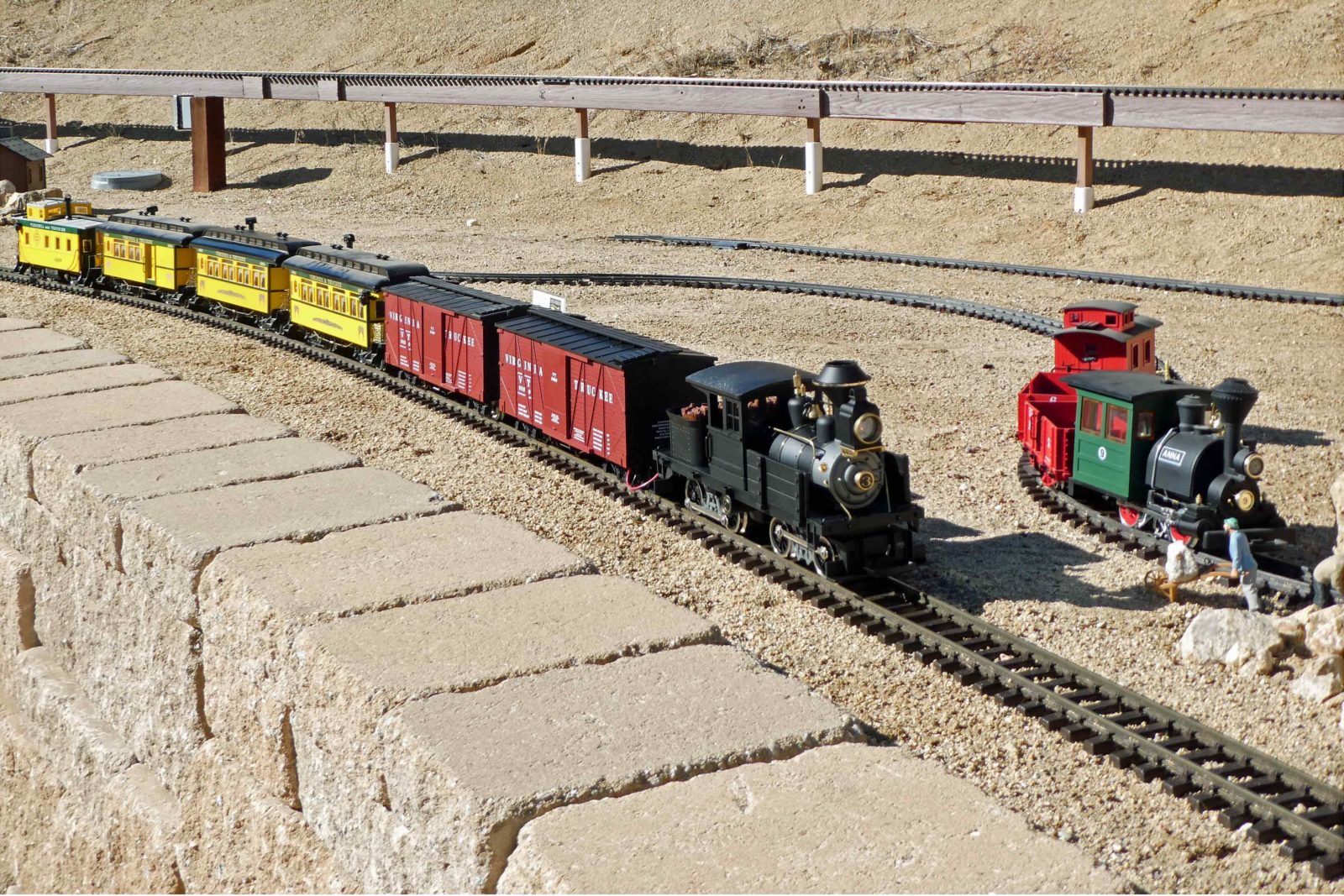 Mark Goodman's battery powered Hartford Locomotive Works' logging engine passes a stationary LGB Porter waiting for tracks to be cleared of a "rock slide."