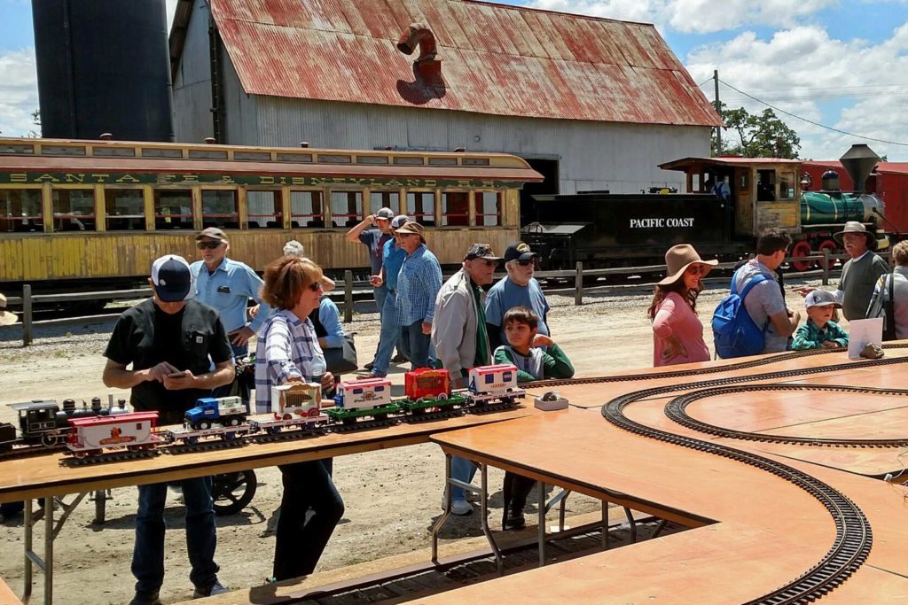 People watch large scale model trains