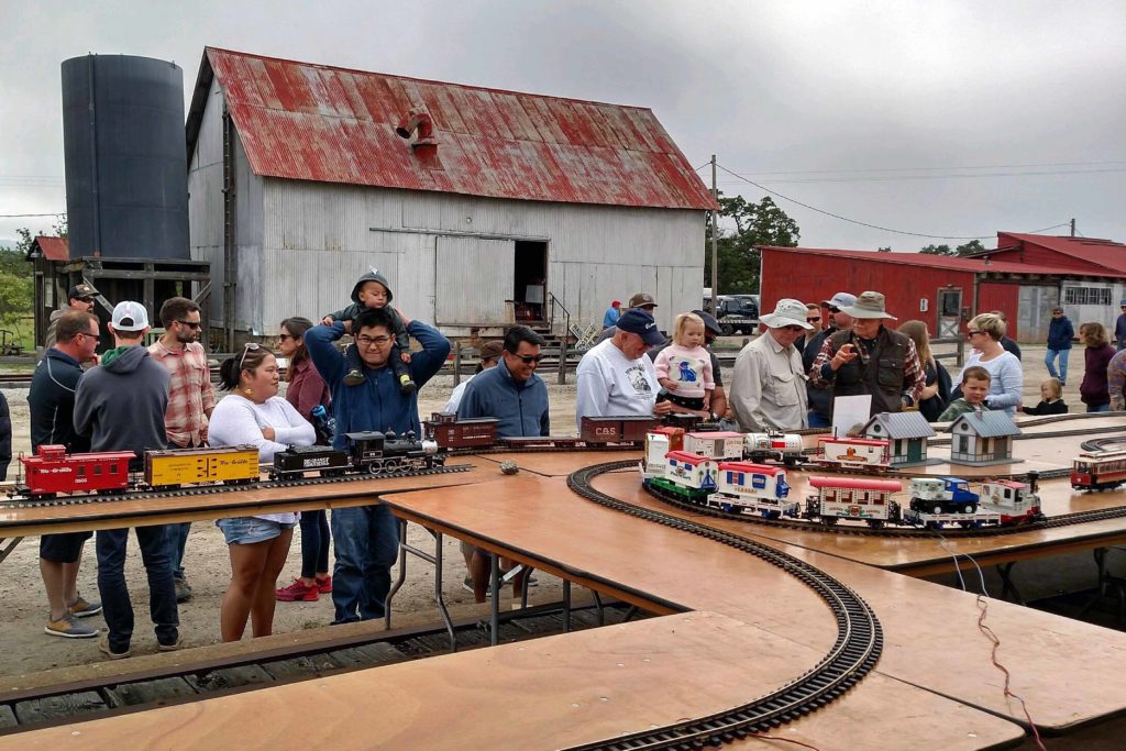 People watch large scale model trains